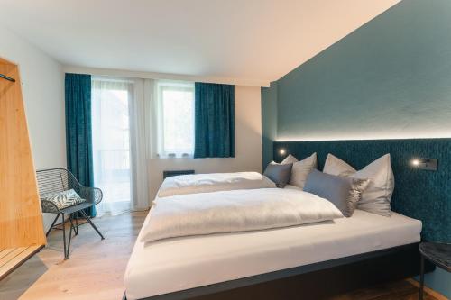 a bedroom with a large bed with a blue wall at Ferienhaus Holzer in Weissensee