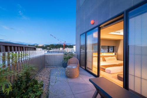 - un balcon avec une chambre et un lit dans un bâtiment dans l'établissement Onn nakatsugawa, à Nakatsugawa