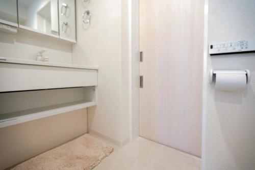 a bathroom with a white door and a toilet paper roll at Asakusa Designer Hotel YOSHII in Tokyo