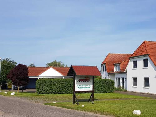 a sign in the grass in front of a house at Ferien-Residenz am Nationalpark Wohnung 6 in Gingst