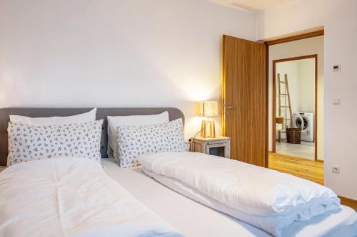 a bedroom with two beds with white sheets and pillows at Eichhof Apartment Lavendel in Termeno