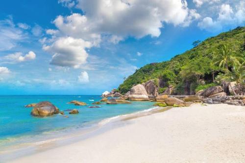 a beach with rocks and the ocean on a sunny day at Silver Beach 3br Sea View Pool&Wine Private Villa in Chaweng