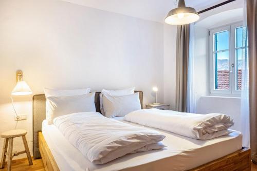 1 dormitorio con 2 camas con sábanas blancas y ventana en Eichhof Apartment Lavendel en Termeno