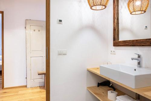 a bathroom with a white sink and a mirror at Eichhof Apartment Lavendel in Termeno