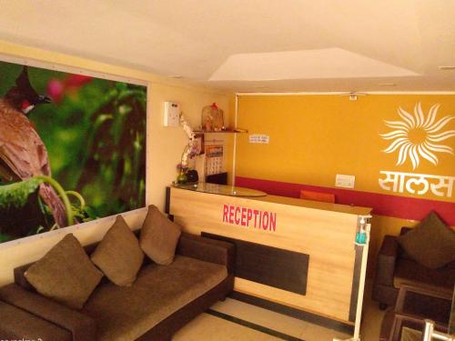 a living room with a couch and a reception counter at Salas Executive in Mahabaleshwar