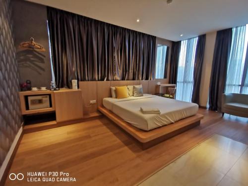 a bedroom with a bed in a room with windows at Kyoto Boutique Hotel in Johor Bahru