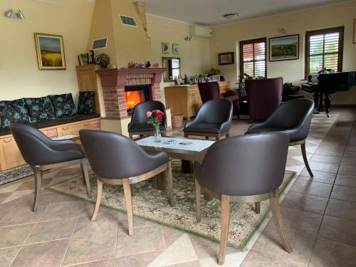 a living room with a table and chairs and a piano at Hostel Strug in Makole