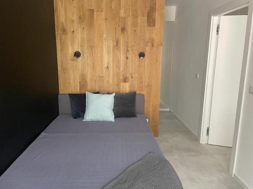a bedroom with a bed with a wooden headboard at Piękny i nowy apartament, z darmowym parkingiem in Łódź