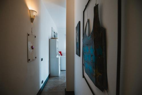 a hallway with a refrigerator and paintings on the walls at Agriturismo Rose di Pietra in Pietra Ligure