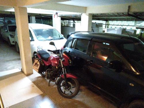 a motorcycle parked next to a car in a garage at SALAS EXECUTIVE in Mahabaleshwar