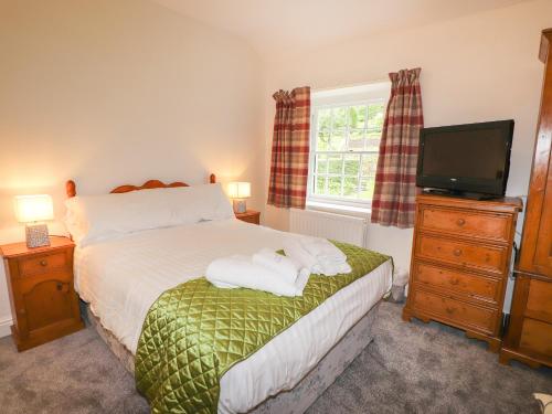 a bedroom with a bed with two towels on it at Millerbeck in Ambleside
