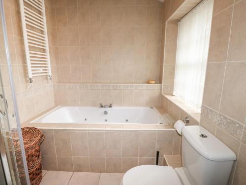 a bathroom with a bath tub and a toilet at Millerbeck in Ambleside