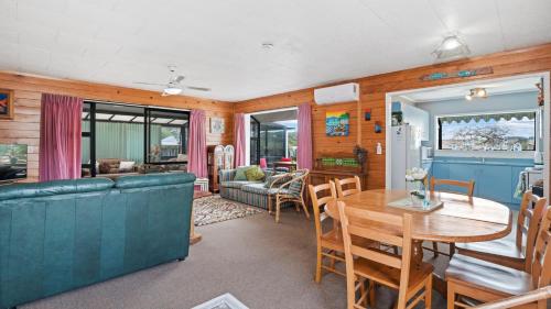 a dining room and living room with a table and chairs at Beachglen - Snells Beach Holiday Home in Snells Beach