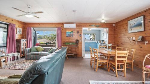 a living room with a couch and a table at Beachglen - Snells Beach Holiday Home in Snells Beach