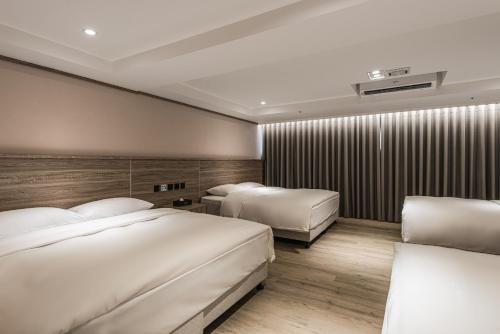 a hotel room with two beds and a wall with at Spring Rhapsody Hotel in Taichung