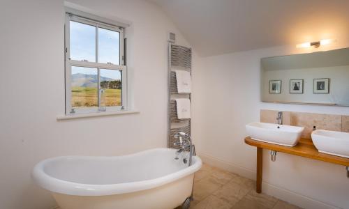 a bathroom with a tub and a sink and a window at Beck View in Troutbeck