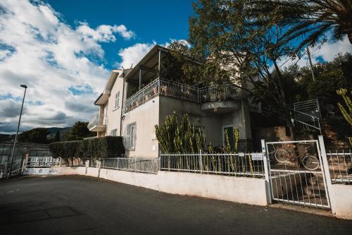 a white house with a fence in front of it at Agriturismo Rose di Pietra in Pietra Ligure
