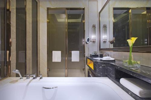 a bathroom with a tub and a large mirror at Wanda Vista Lanzhou in Lanzhou