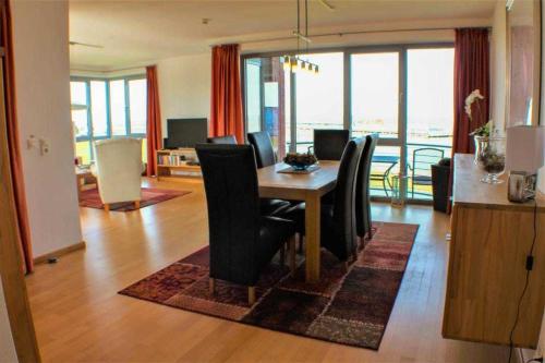 uma sala de jantar com uma mesa e cadeiras num quarto em Residenz Atlantic em Cuxhaven