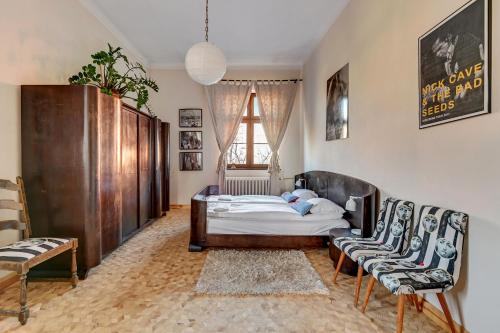 a bedroom with a bed and two chairs at Danzig 1925 Old Town Apartment in Gdańsk