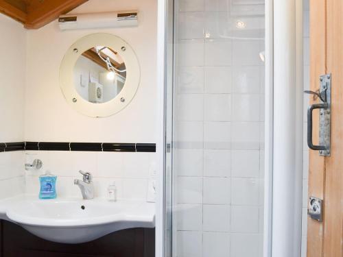 La salle de bains est pourvue d'un lavabo et d'un miroir. dans l'établissement The Boat House, à Lochmaddy