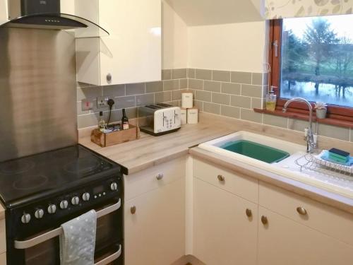 a kitchen with a stove and a sink at Riverside View in Nairn
