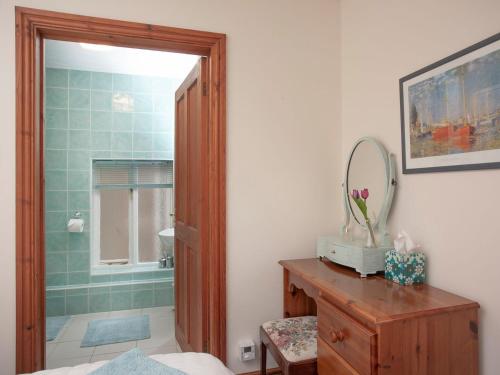 uma casa de banho com um chuveiro e um toucador com um espelho. em The Stables em Clyst Saint Mary