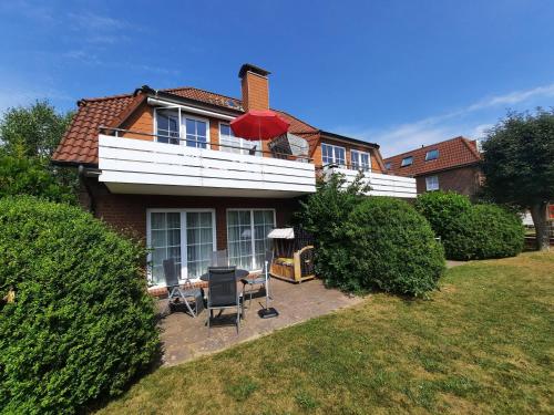 una casa con un paraguas rojo encima en Residenz Vogelsand 1, en Cuxhaven