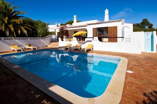 a swimming pool in front of a house at Casa ADM42 in Carvoeiro