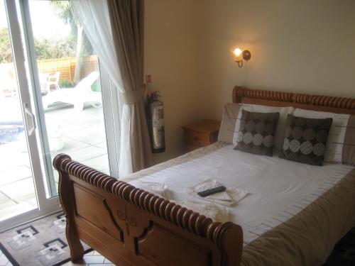 a bedroom with a bed and a sliding glass door at Priory Lodge Hotel in Newquay