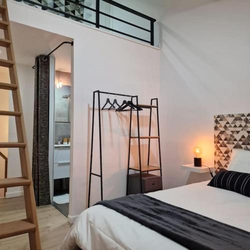 Schlafzimmer mit einem Bett, einer Leiter und einem Spiegel in der Unterkunft L’atelier C magnifique Loft avec terrasse privée in Saint-Étienne