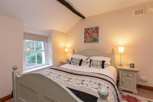 1 dormitorio con 1 cama con 2 almohadas y ventana en Swinside Cottage en Keswick