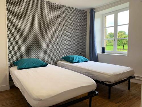 two twin beds in a room with a window at Maison de 4 chambres avec vue sur le lac et jardin amenage a Joue du Bois in Joué-du-Bois