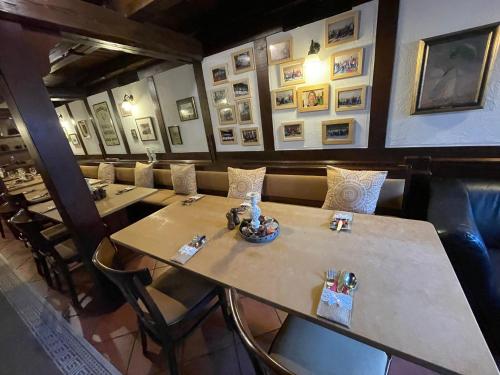 une rangée de tables dans un restaurant avec des photos sur les murs dans l'établissement Landhotel & Restaurant Kains Hof, à Uhlstädt