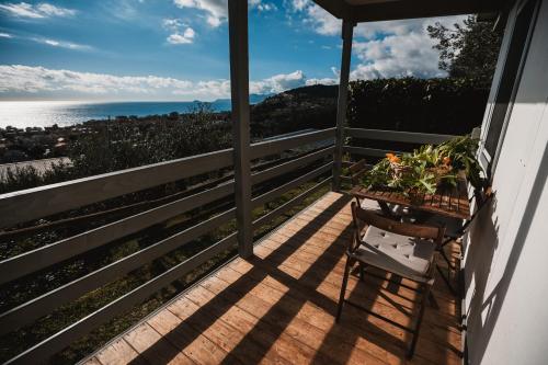 a porch with a chair and a view of the ocean at Agriturismo Rose di Pietra in Pietra Ligure