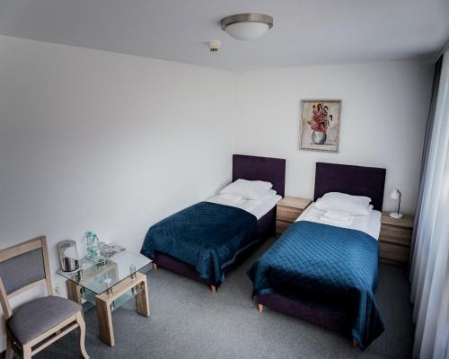 a hotel room with two beds and a table at Ośrodek Konferencyjno-Wypoczynkowy "Parzenica" w Zakopanem in Zakopane