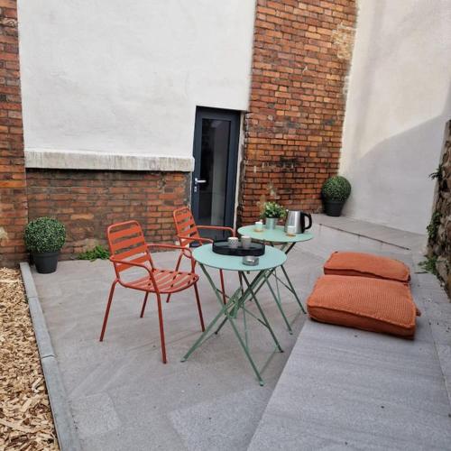un patio con mesa, 2 sillas, mesa y mesa en Grand Loft avec terrasse privée, en Saint-Étienne