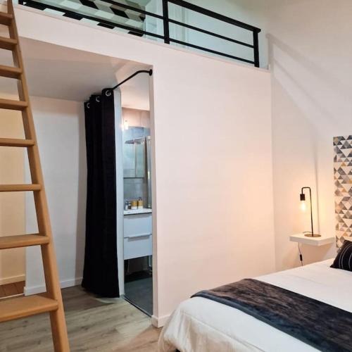 1 dormitorio con litera, escalera y espejo en Grand Loft avec terrasse privée, en Saint-Étienne