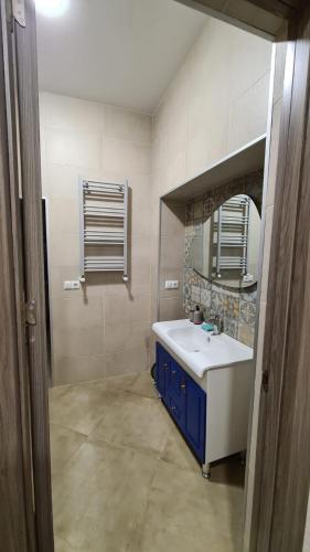 a bathroom with a sink and a mirror at Nino's Cosy Apartment in Kutaisi