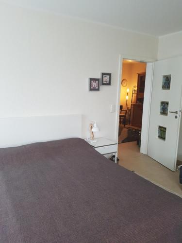 a white room with a large bed and a hallway at Appartement am Goldsteinpark in Bad Nauheim