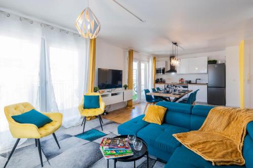 a living room with a blue couch and a kitchen at CAOPEO - Top Hôte Paris - 8 personnes Balcon Parking in Saint-Denis