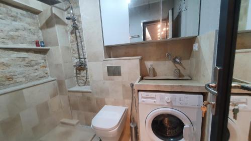 Un pequeño baño con lavadora y lavabo. en TOMIS Studio 4B, en Constanţa