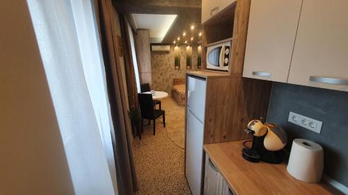 une petite cuisine avec un réfrigérateur et une table dans l'établissement TOMIS Studio 4B, à Constanţa