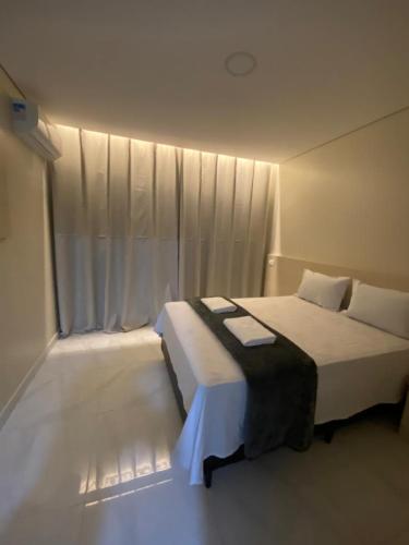 a bedroom with a white bed with a window at Hotel Flex Tatuapé in Sao Paulo