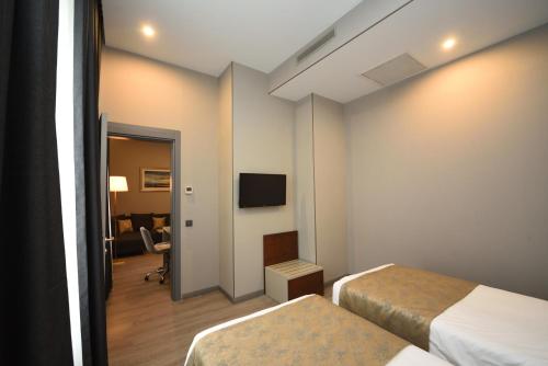 a hotel room with two beds and a tv at Tbilisi Chambers, Trademark Collection by Wyndham in Tbilisi City