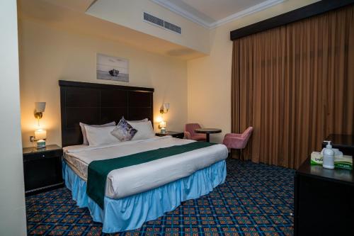 una habitación de hotel con una cama grande en una habitación en Royal Prestige Hotel en Dubái