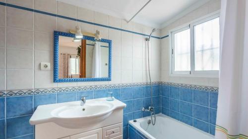 馬羅的住宿－Villa Tranquila Nerja by Ruralidays，蓝色和白色的浴室设有水槽和浴缸。