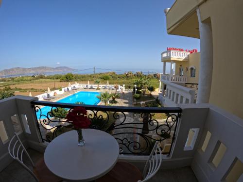 a balcony with a table and a view of a pool at Palladion Hotel in Georgioupolis