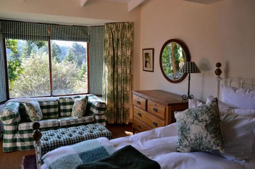 a living room with a couch and a window at Dullies Cottage in Dullstroom