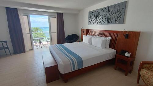 a bedroom with a bed with a view of the ocean at Aira Boracay Hotel in Boracay